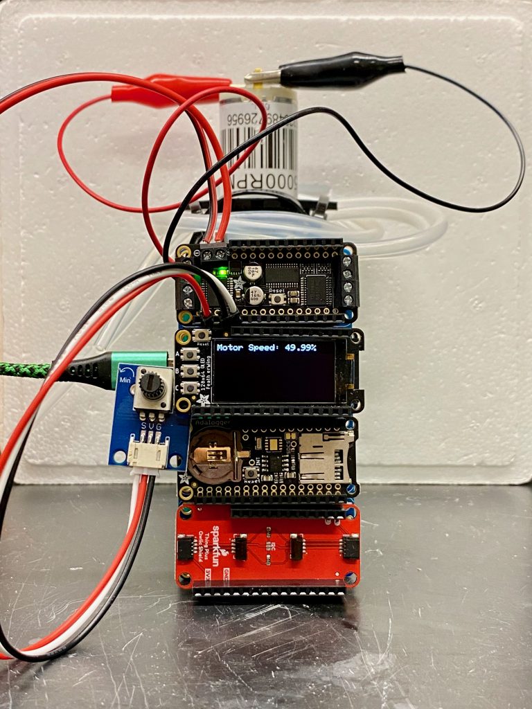 A small series of rectangular electronic components connected together. One rectangle is connected to a small water pump, while another is connected to a turn knob labeled "motor speed"