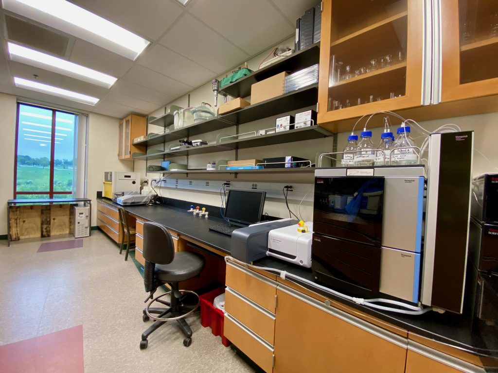 A photo of the lab bench space in ABL 313, specifically showing the larger pieces of scientific equipment. Tubes are streaming from bottles to various points within the instruments.